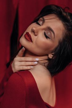 Elegant woman in a red dress embodies sophistication and sensuality with a graceful pose.
