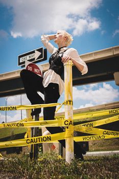 Stylish person poses confidently surrounded by caution tape at a construction site.