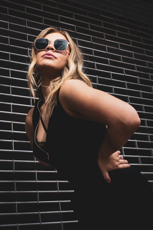 Woman Bending against Black Brick Wall