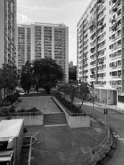Free A black and white cityscape featuring residential high-rise buildings and a central courtyard. Stock Photo