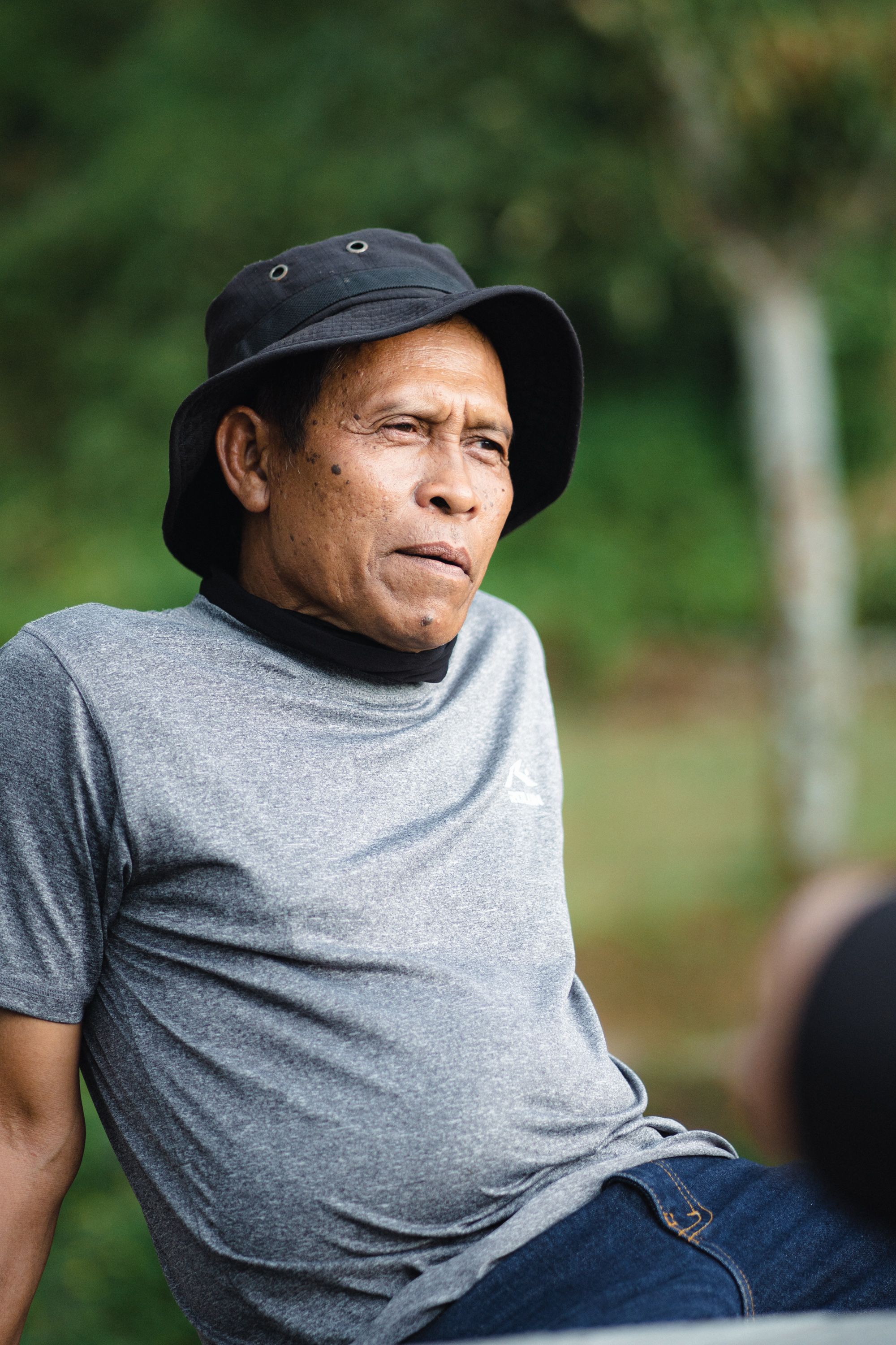 Casual outdoor portrait of a man in a t-shirt and bucket hat enjoying leisure time.