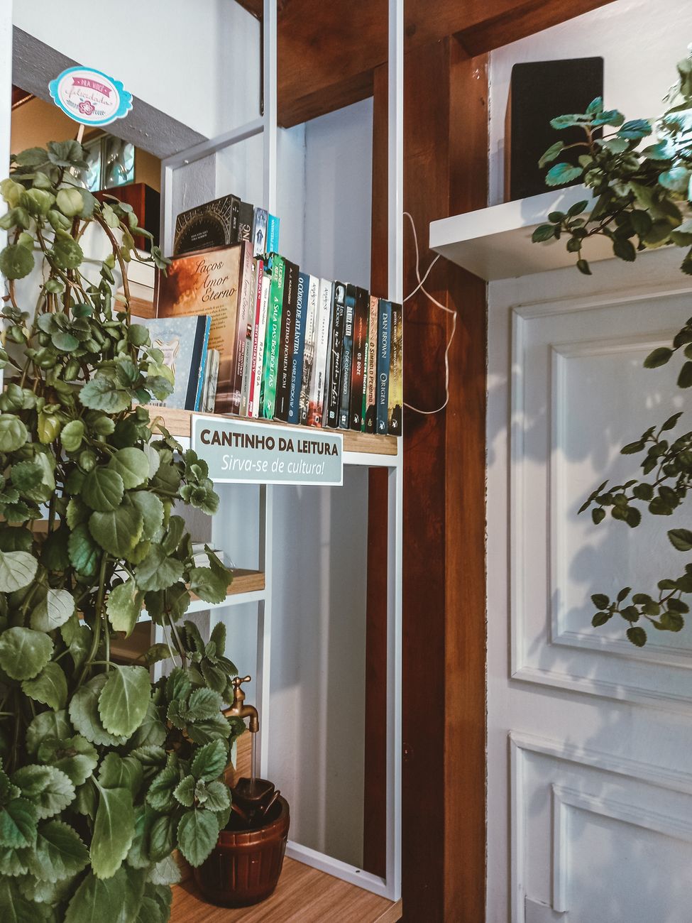 A charming reading corner with books and lush houseplants in a home interior.