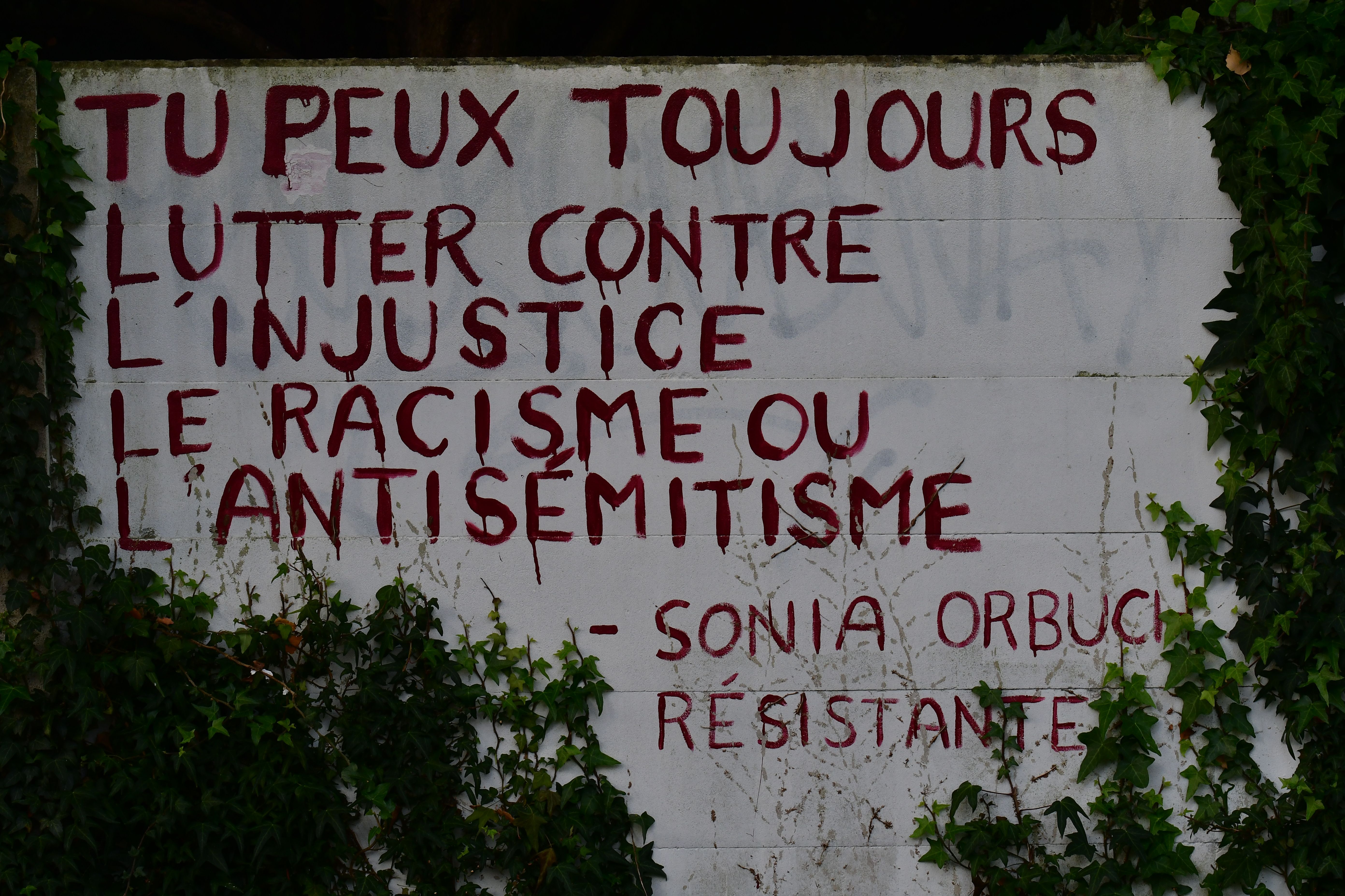 Graffiti on wall with a powerful message against injustice and racism in French.