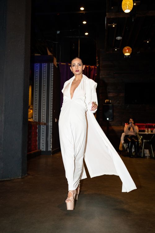 Free A stylish woman in a white dress elegantly walks indoors, showcasing modern fashion and sophistication. Stock Photo