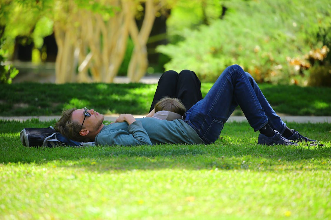 Free Man Wearing Blue Long Sleeve Shirt Lying on Ground during Daytime Stock Photo