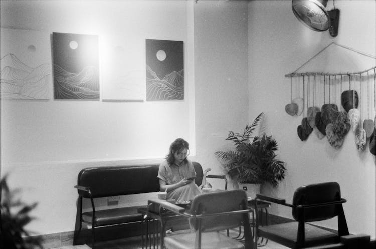 Woman Sitting In Room In Black And White