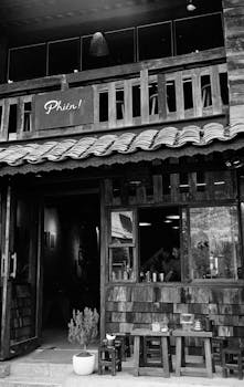 A rustic wooden café entrance captured in monochrome, showcasing urban charm.