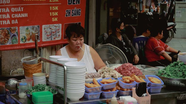Mature woman vendor prepares street food ingredients at an outdoor market.