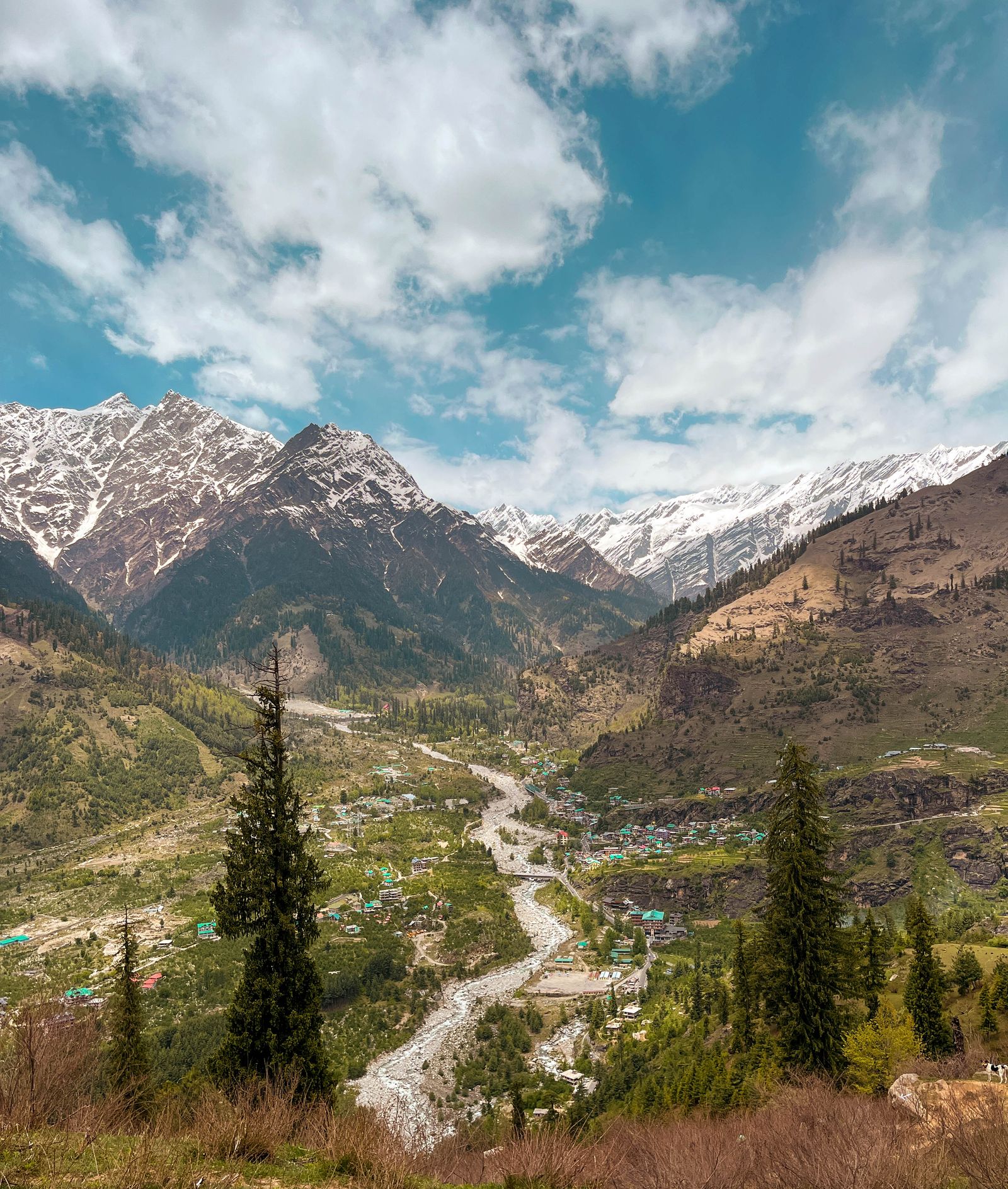 Village nestled in snowcapped mountain valley near Manali