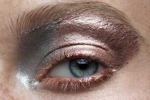 Extreme close-up of a person's eye with metallic eyeshadow and detailed skin texture.