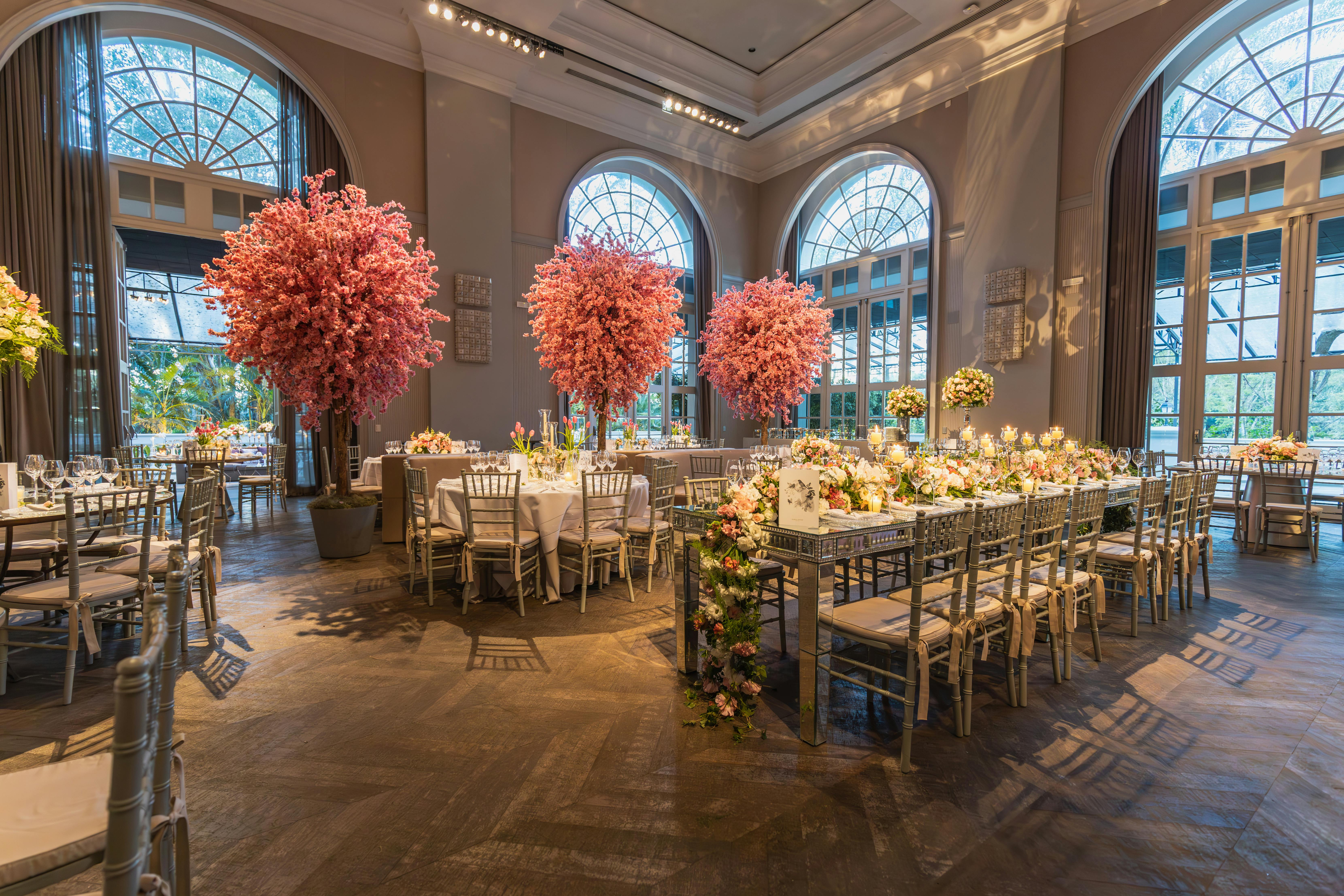 Luxurious wedding reception with elegant decor and floral arrangements in a grand hall.