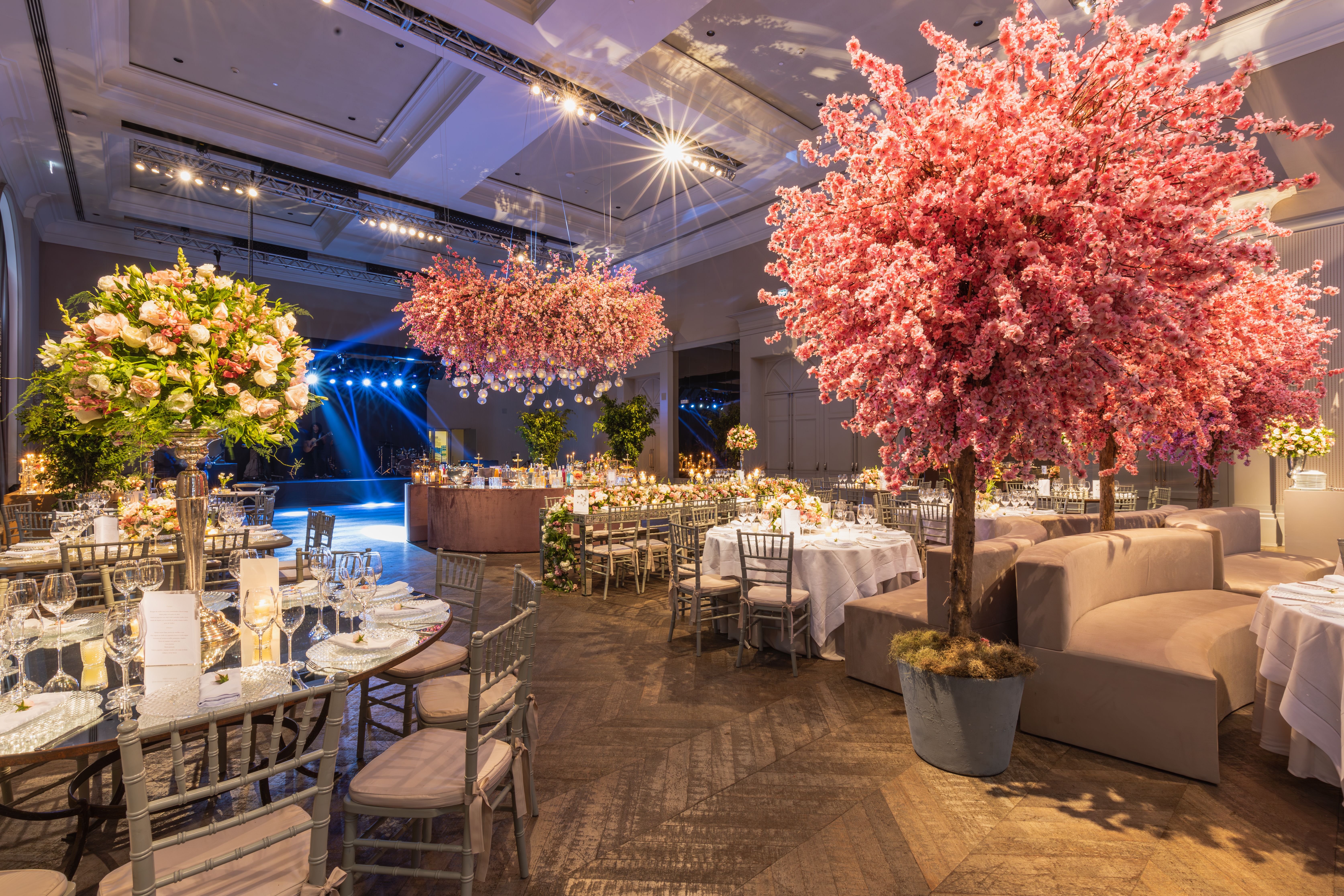 Elegant wedding reception with cherry blossoms and lavish decor in a luxurious setting.