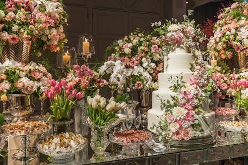 A Table with a Layer Cake and Variety of Sweets Decorated with Flowers 