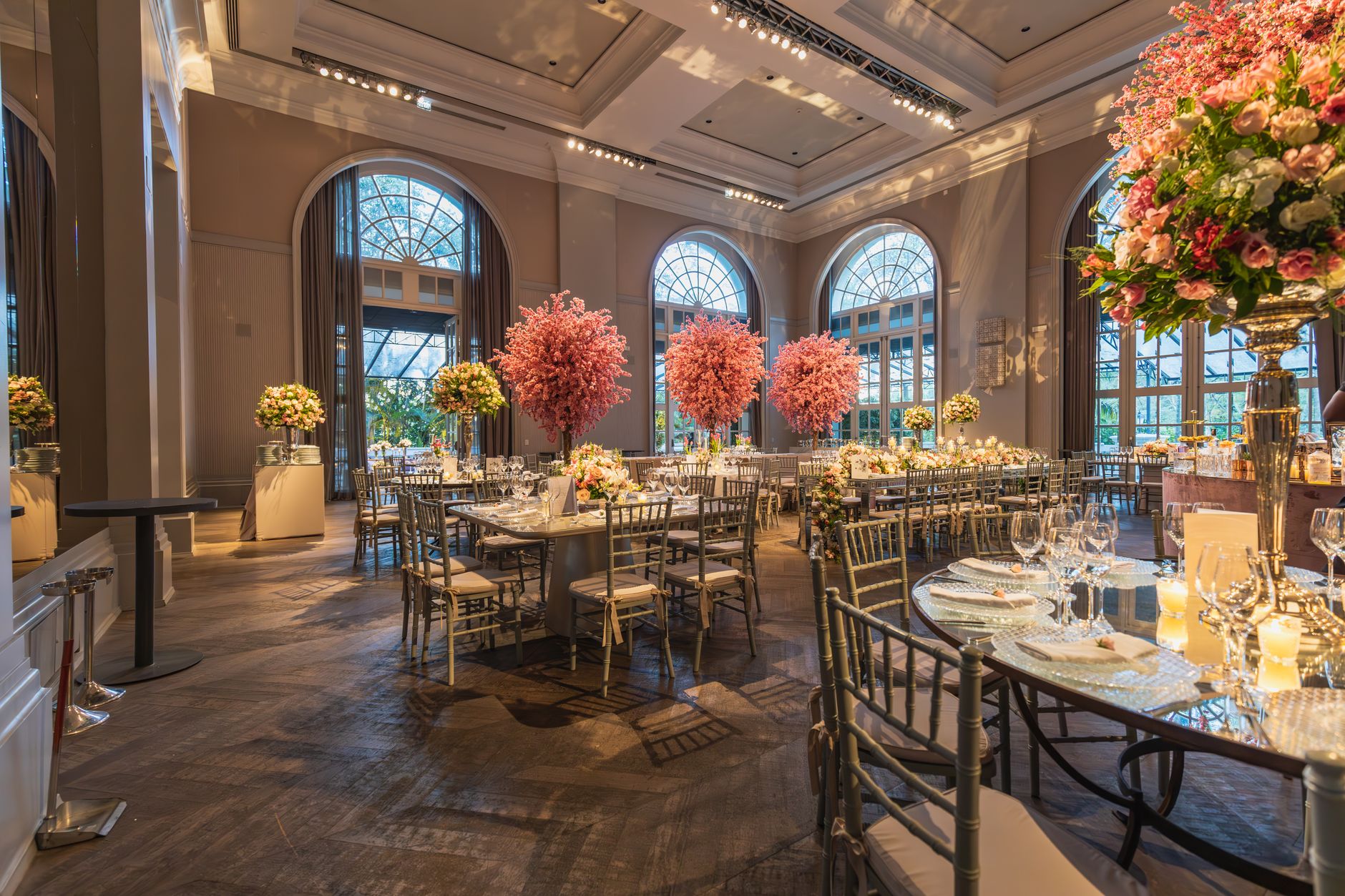 Luxurious wedding reception hall with elegant floral decorations and tasteful table settings.