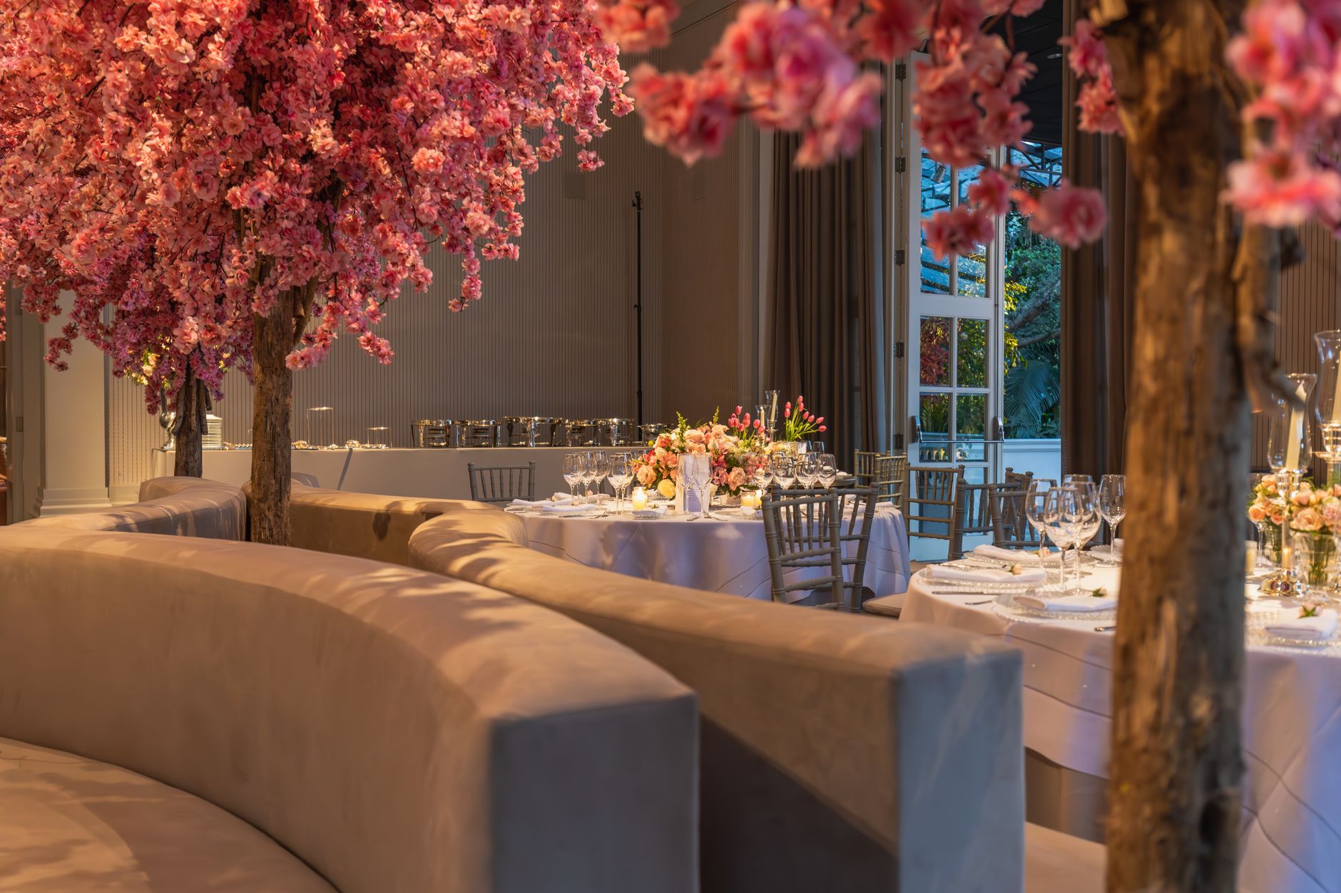 Beautifully decorated wedding venue with pink floral accents and elegant dining setup.