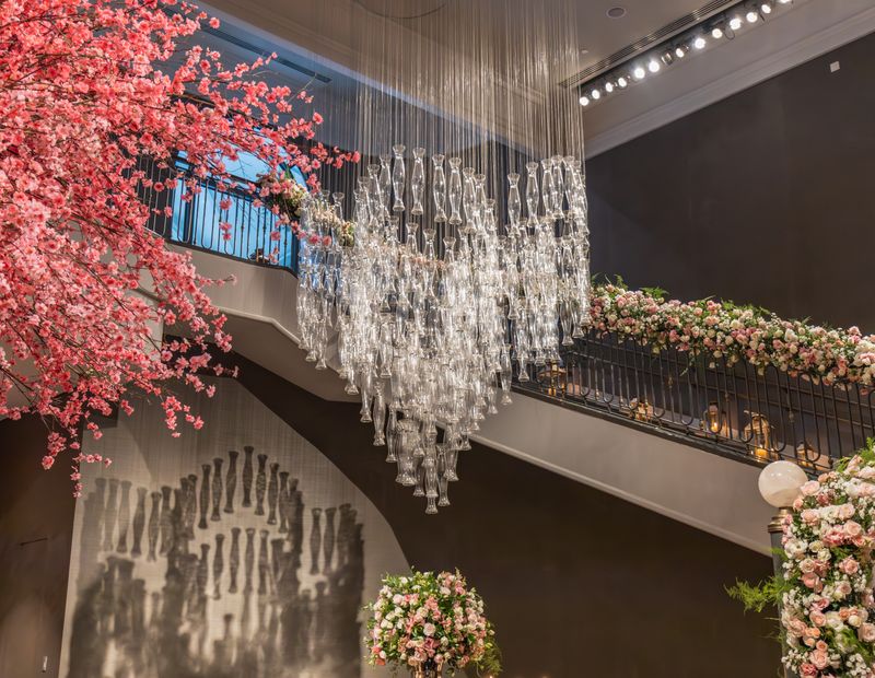 Floral staircase decoration beneath a chandelier