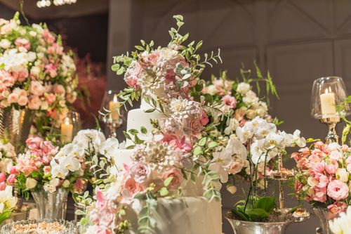 Free Luxurious wedding cake adorned with elegant pink and white flowers, creating a romantic atmosphere. Stock Photo
