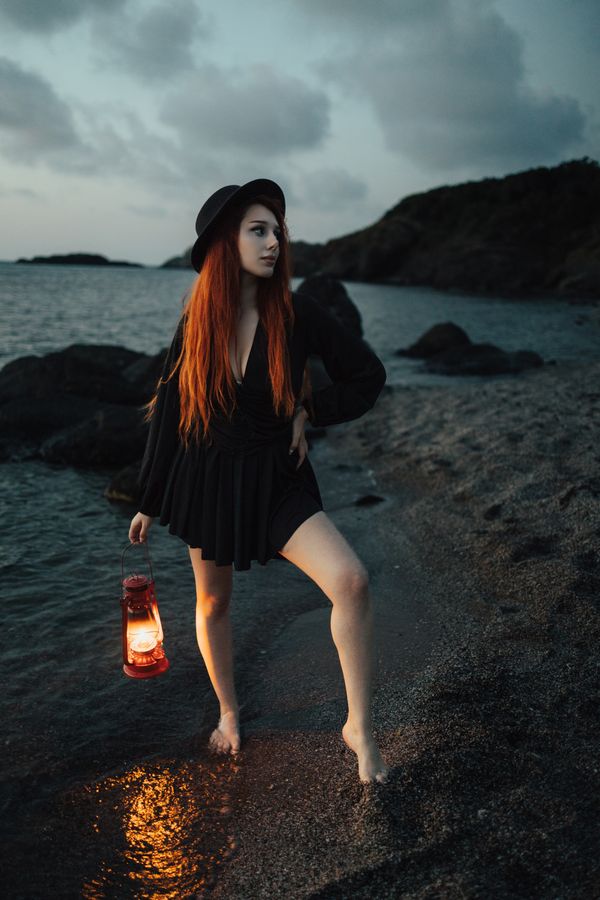 Stylish woman with lantern on pier near lake at night · Free Stock Photo