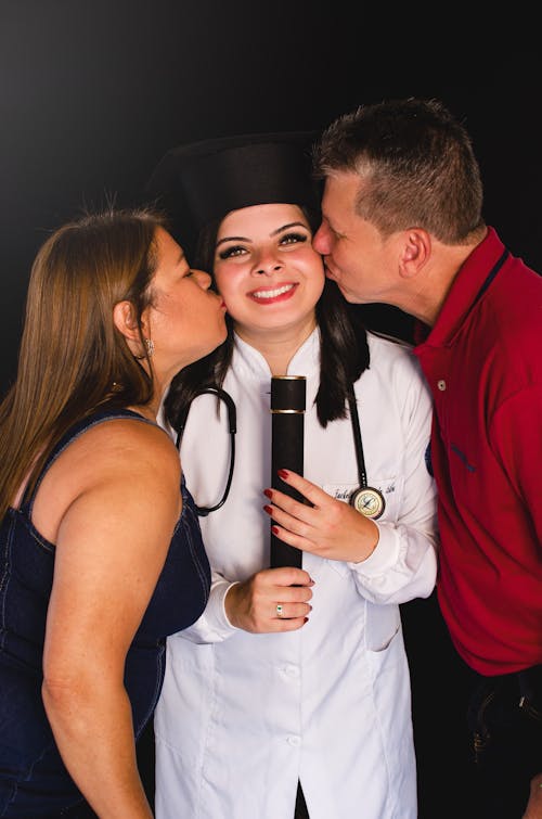 Mother and Father Kissing Doctor Daughter