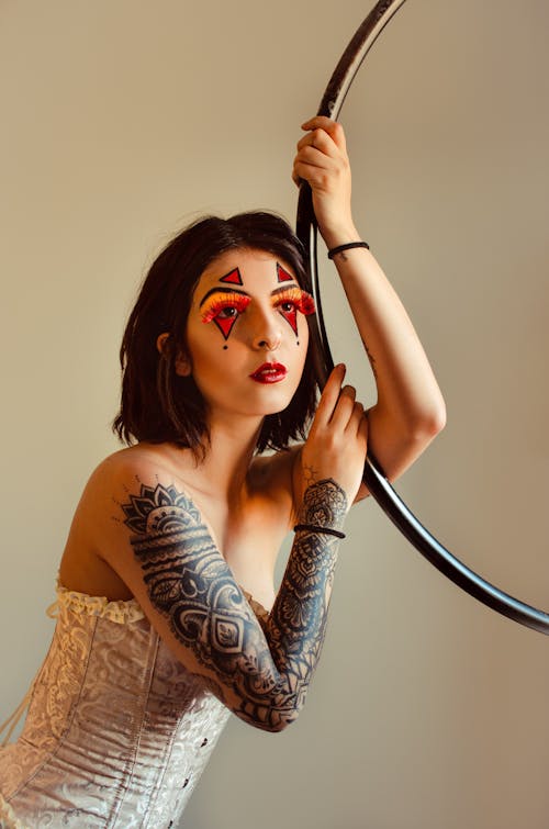 Woman with Tattoos Posing with Makeup on Face