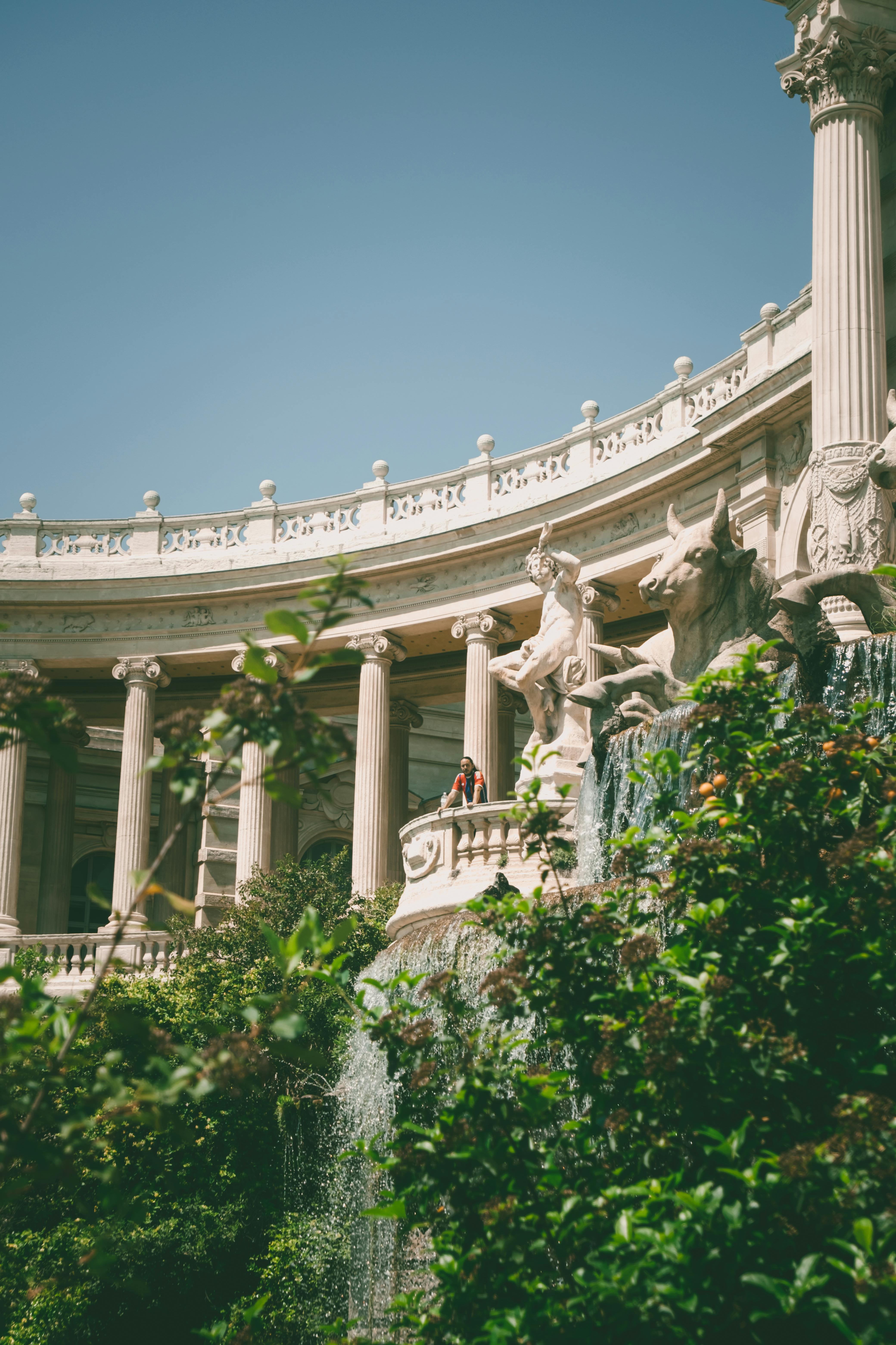 A scenic view of the Palais Longchamp with statues and columns in Marseille, France.