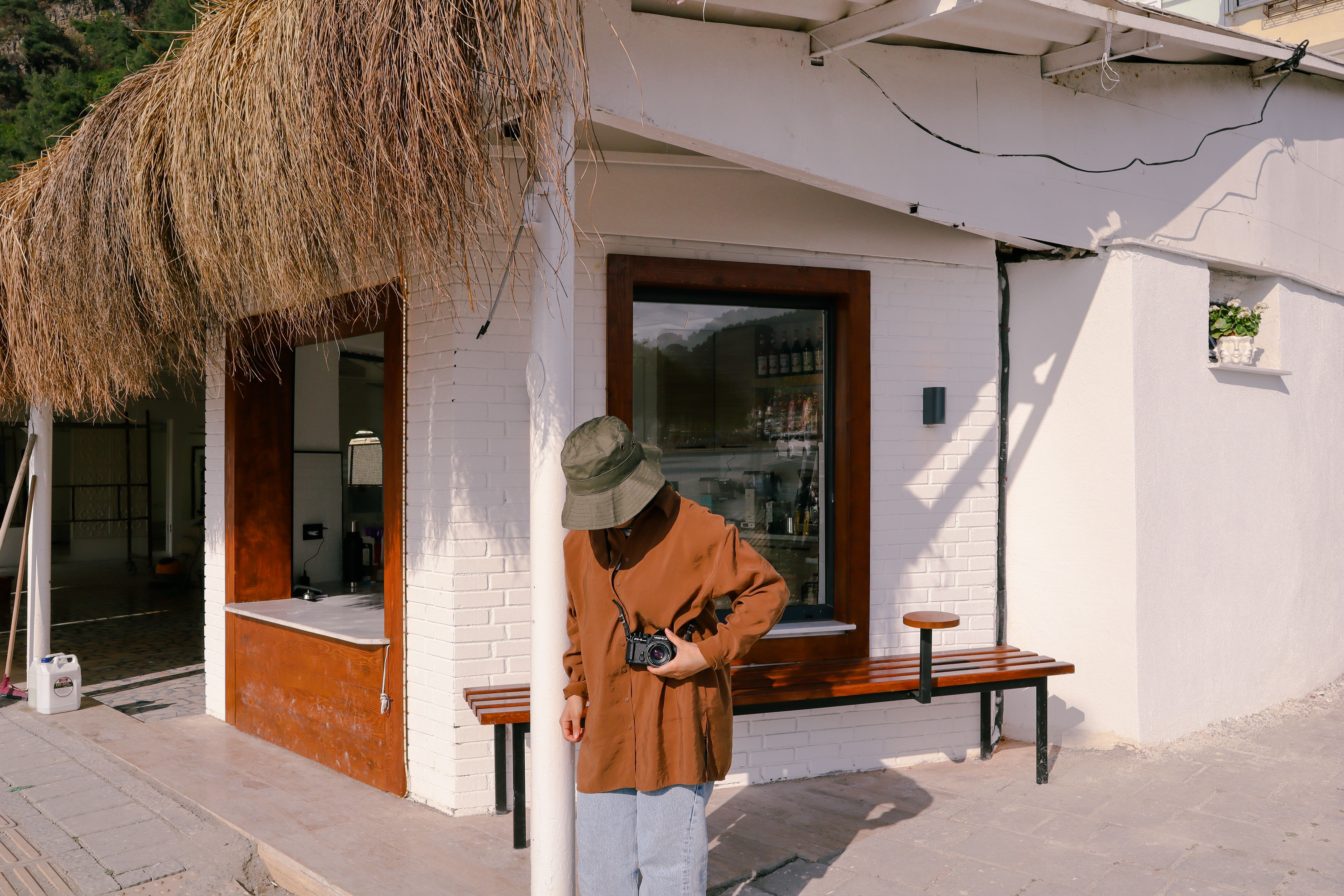 Young woman with a camera at a stylish outdoor cafe, capturing moments.