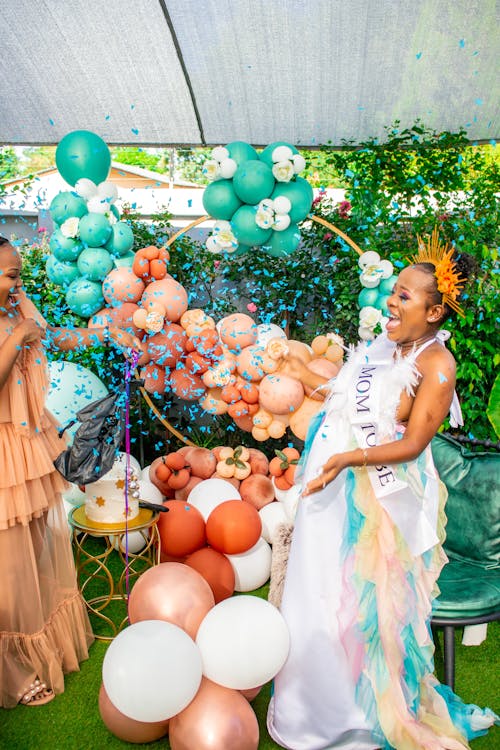 Free Mother-to-be Happy with Blue Confetti at Gender Reveal Party in the Garden Stock Photo