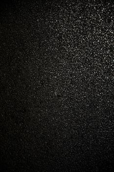 A high-resolution close-up of a black asphalt surface, perfect for backgrounds or graphic design.