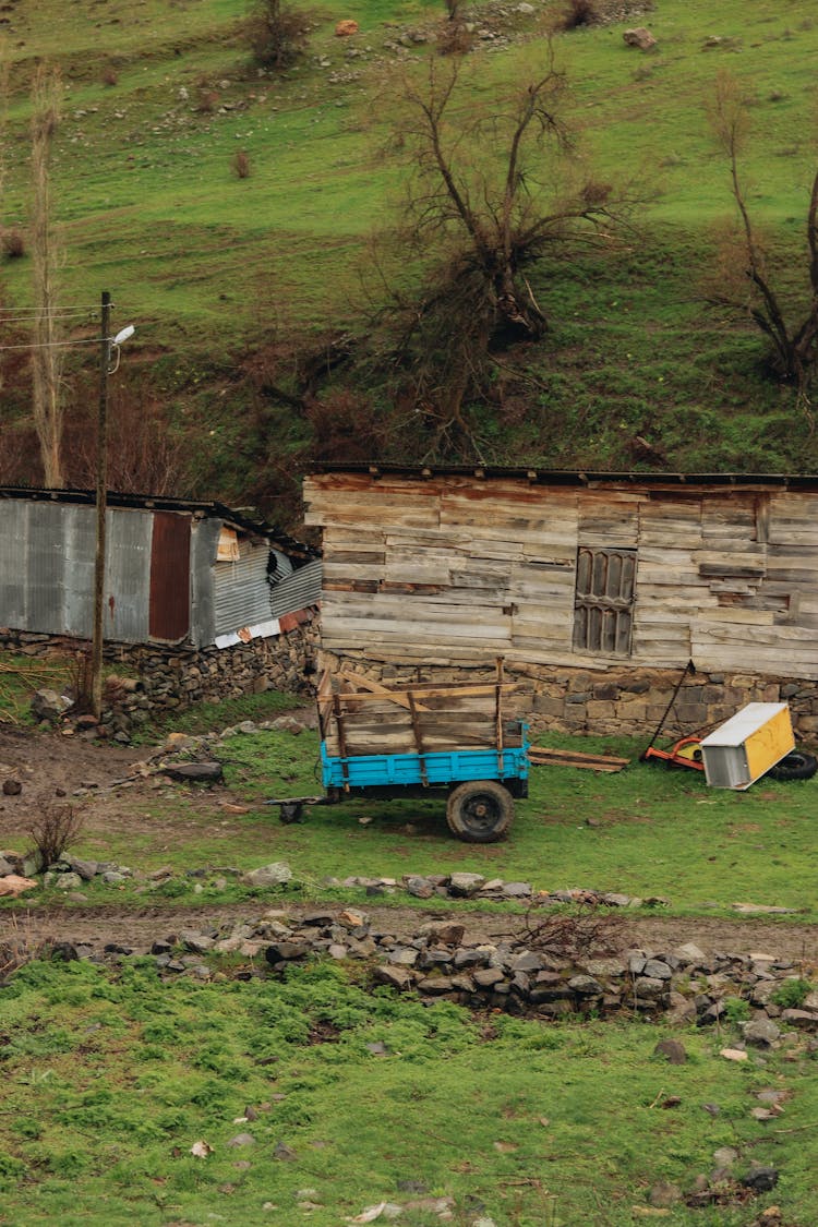 Tractor Trailer And Wooden Sheds On A Mountain Farm