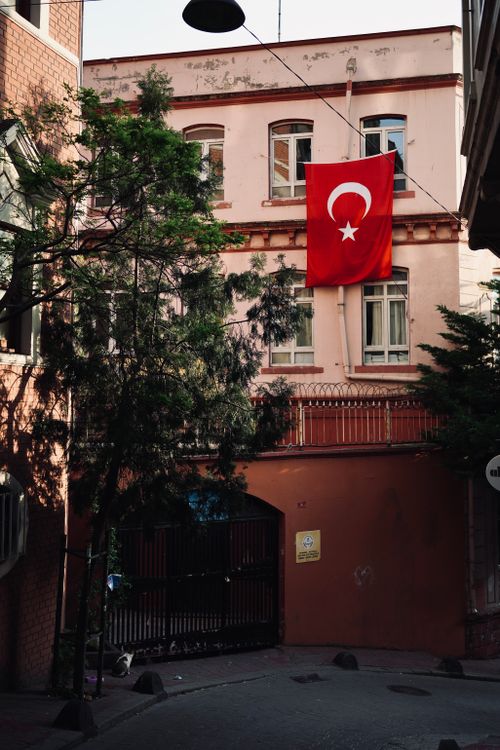 Free Peaceful alleyway view with a Turkish flag on an old building in daylight. Stock Photo