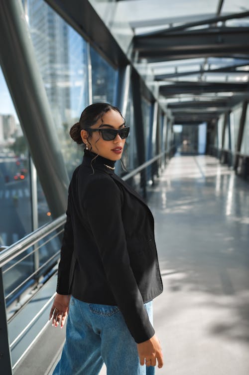 Woman in Black Suit Posing on Footbridge