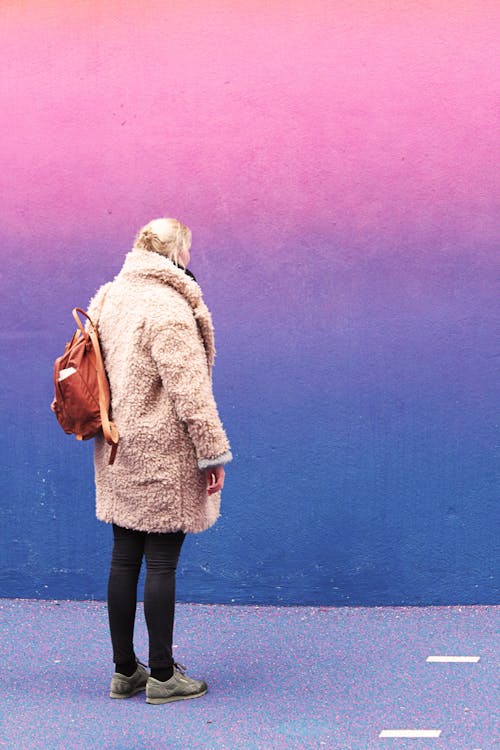 站在粉红色和蓝色的墙前的女人