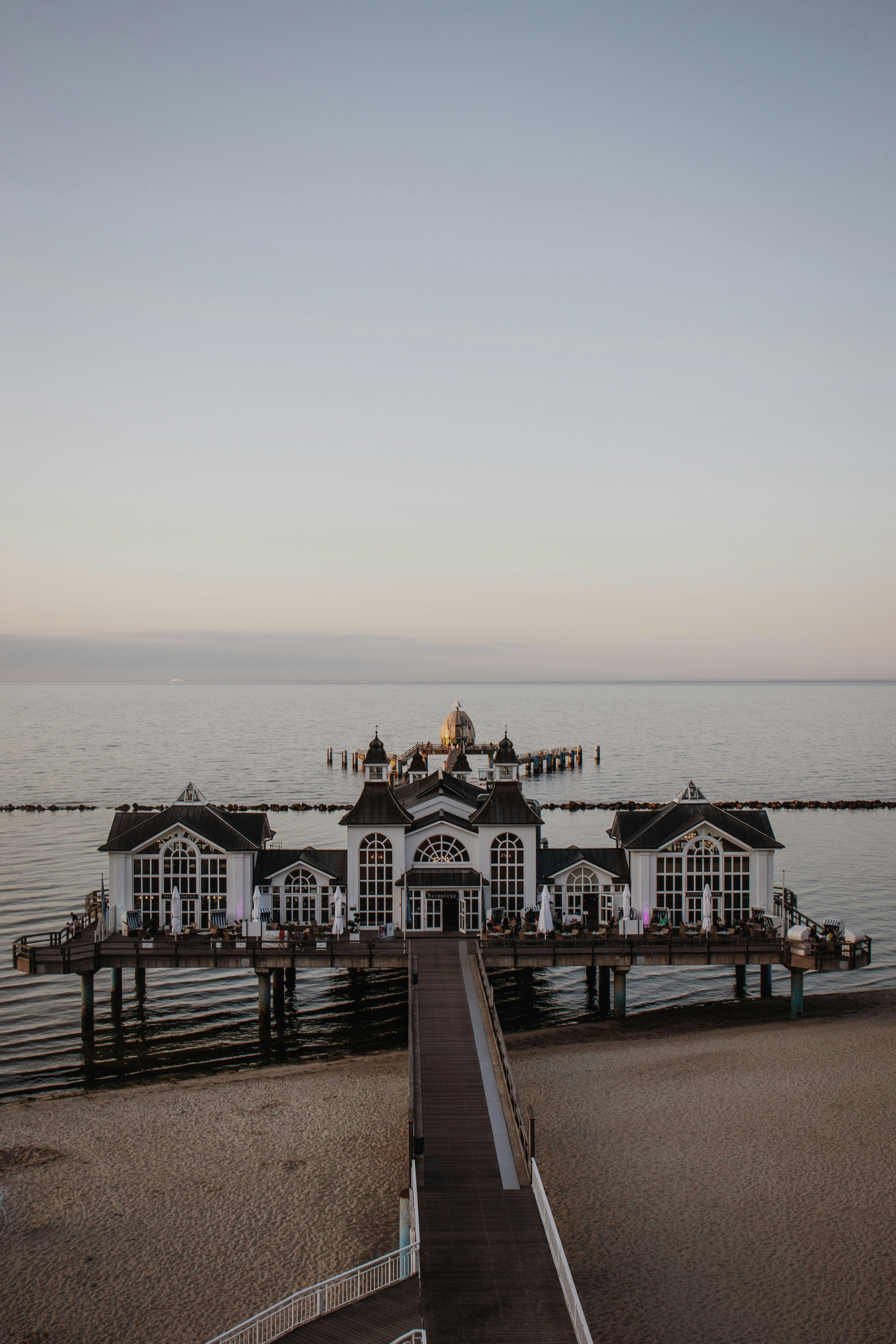 A serene aerial view of Sellin Pier in Germany at sunrise, showcasing its architecture against the calm sea.