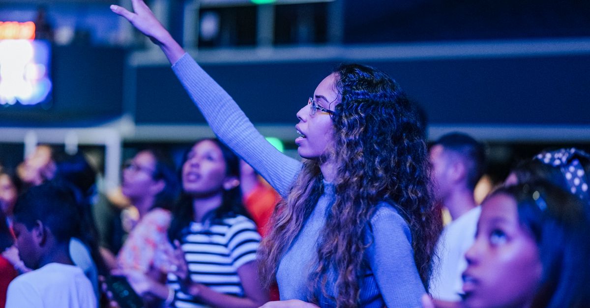 vibrant worship scene at Christ Embassy Ho with people raising hands
