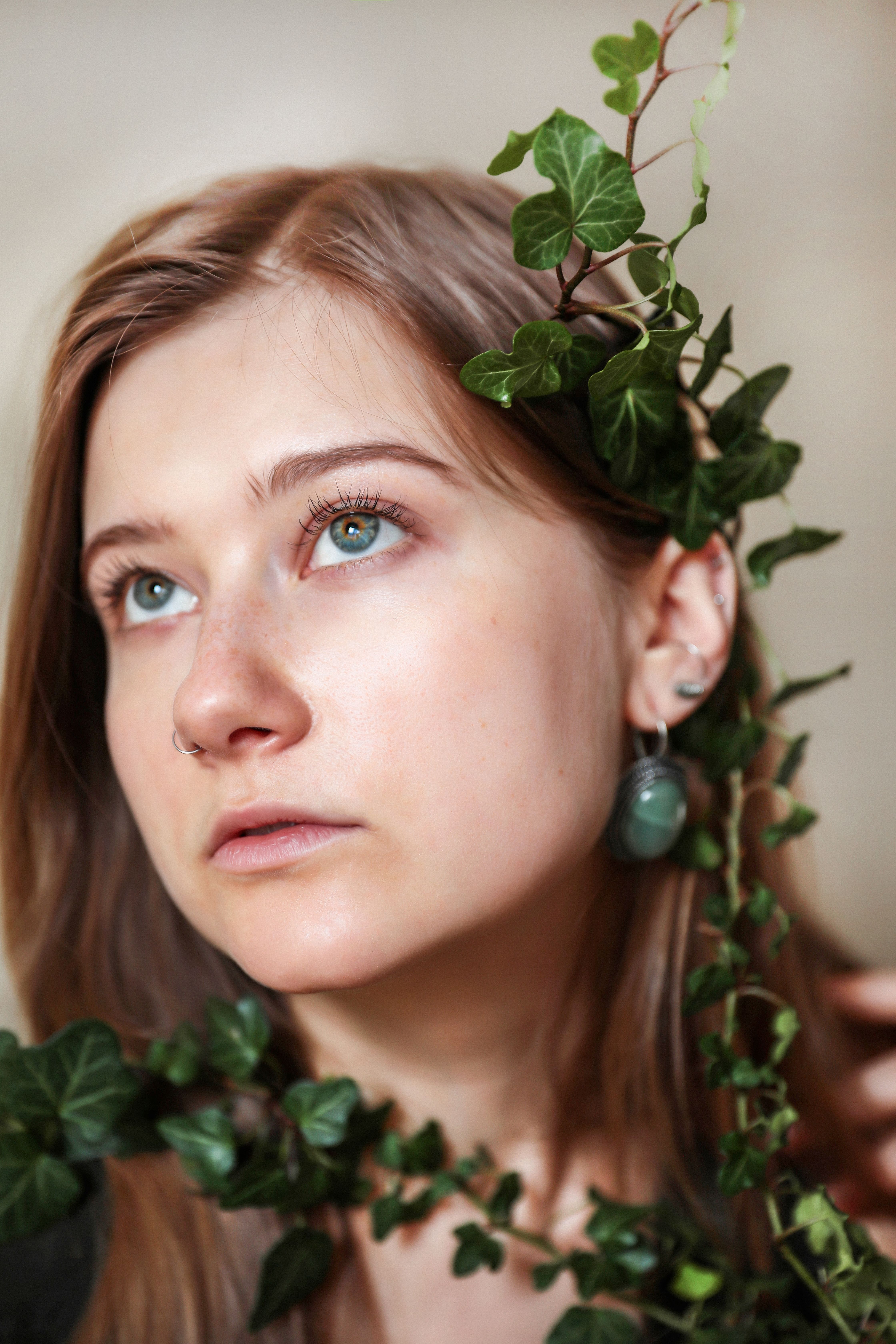 Stunning portrait of a woman adorned with lush green ivy, creating a natural and artistic look.