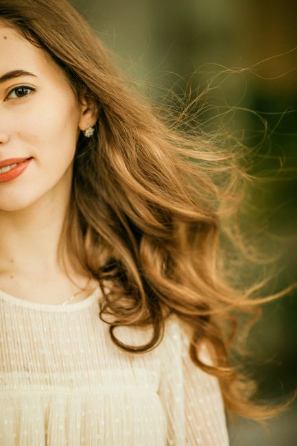 Captivating outdoor portrait of a woman with flowing brown hair in a subtle breeze.