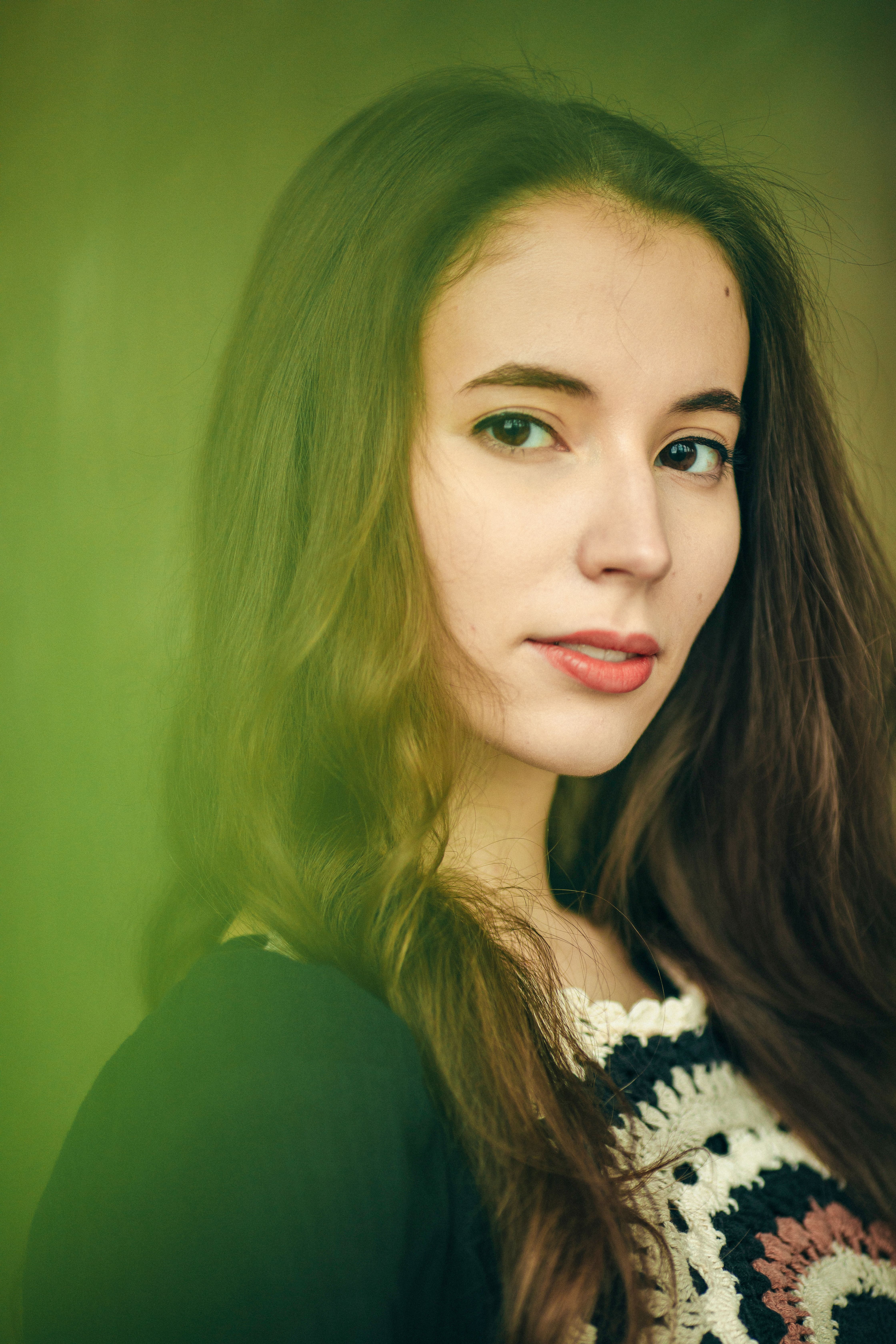 Elegant portrait of a young woman with long brunette hair and a serene expression.