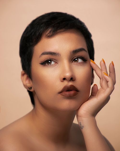 Free Close-up portrait of a woman with short hair and anchor tattoo, showcasing elegance and style. Stock Photo