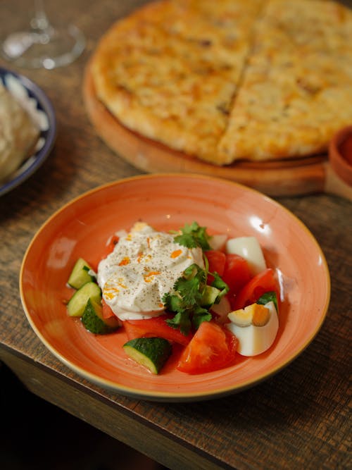 Plate of Vegetable Salad and Pizza on a Table