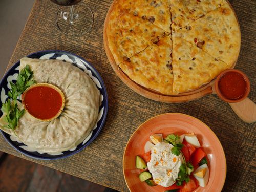 Free Flat lay of diverse Middle Eastern dishes including pizza and salad on a rustic table setting. Stock Photo