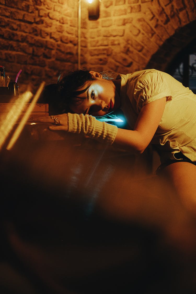 Young Woman Putting Her Head On The Counter In A Dark Interior 