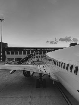 Monochrome photo of an airplane at Denizli Çardak Airport, Türkiye, highlighting aviation travel.