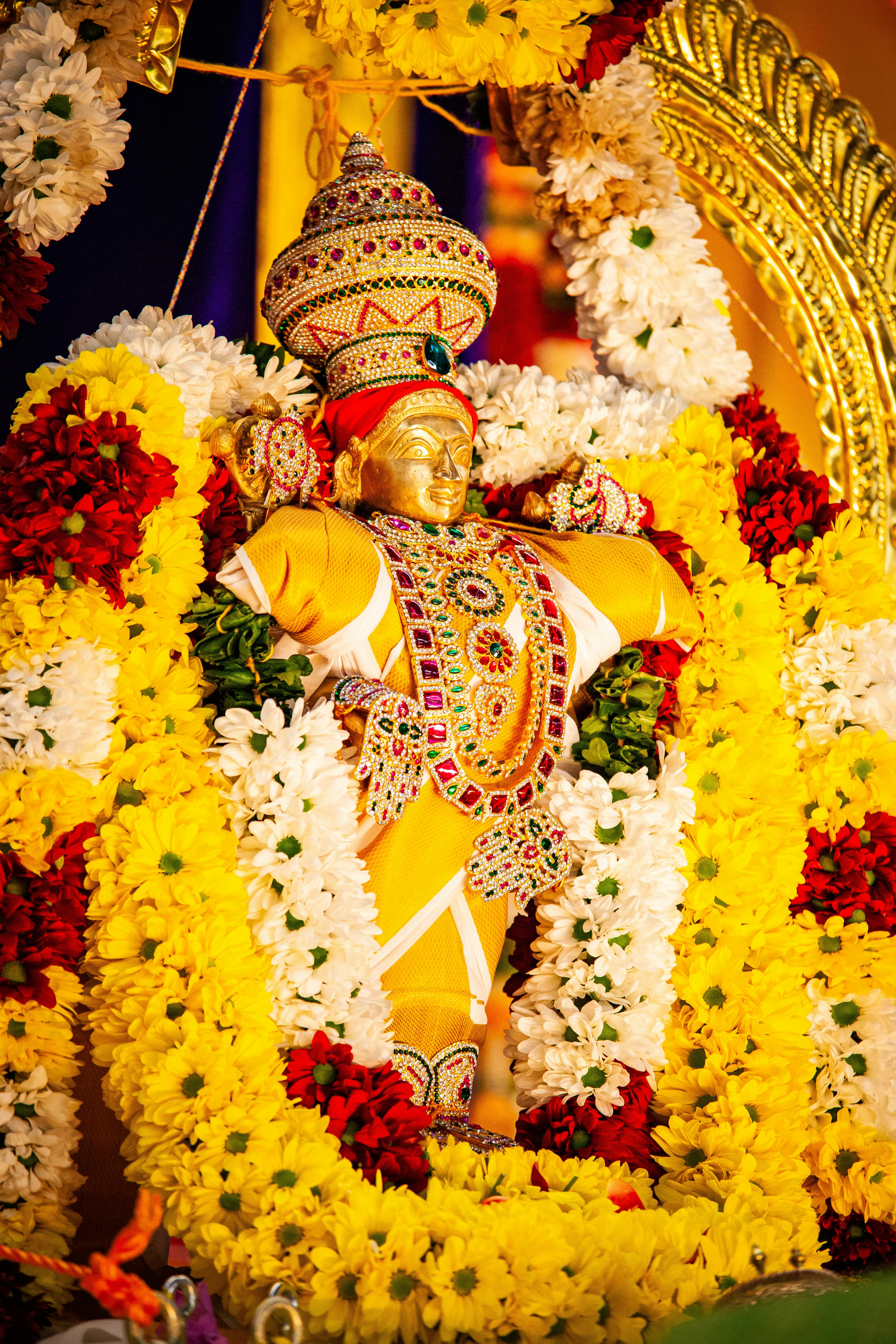 Colorful Hindu deity statue adorned with vibrant floral garlands, capturing cultural and religious essence.
