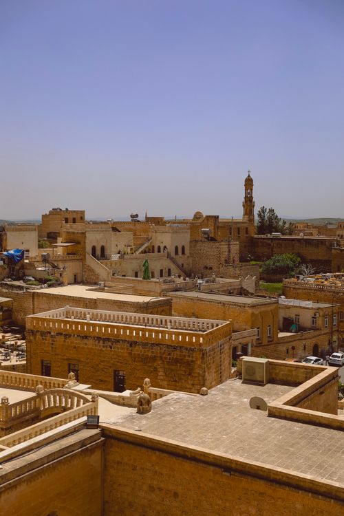 Free Scenic view of Midyat's ancient stone buildings under a clear blue sky in Turkey. Stock Photo