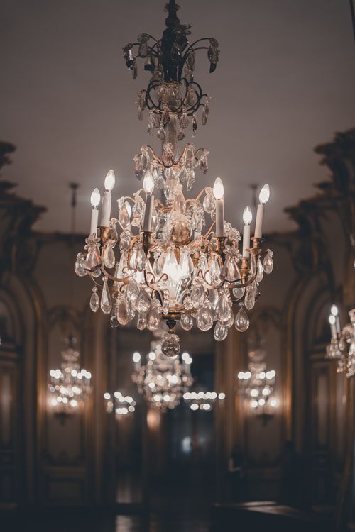 Free Elegant crystal chandelier glowing in a luxurious, neoclassical palace interior showcasing opulent design. Stock Photo