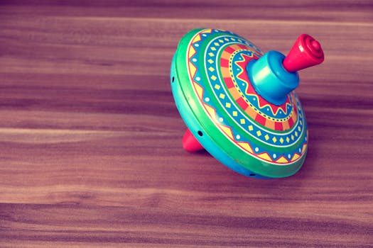 木桌上放着色彩鲜艳的老式旋转陀螺玩具，唤起童年的回忆和俏皮的怀旧之情