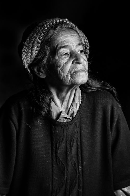 Free Black and white portrait of an elderly woman with a pensive expression, highlighting age and wisdom. Stock Photo