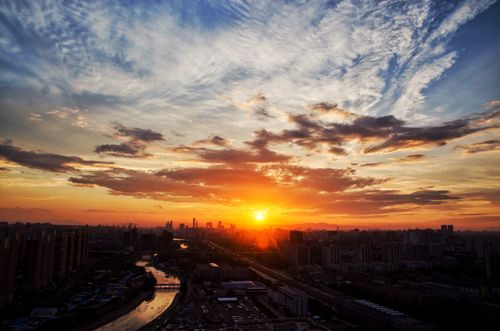 Free A breathtaking cityscape at sunset with vibrant colors and a dramatic sky. Stock Photo