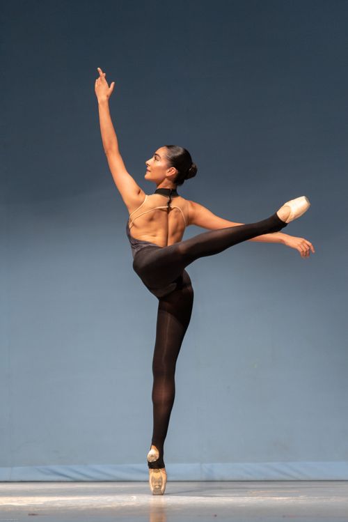 Free Ballerina showcasing flexibility and grace in a stunning dance pose on stage. Stock Photo