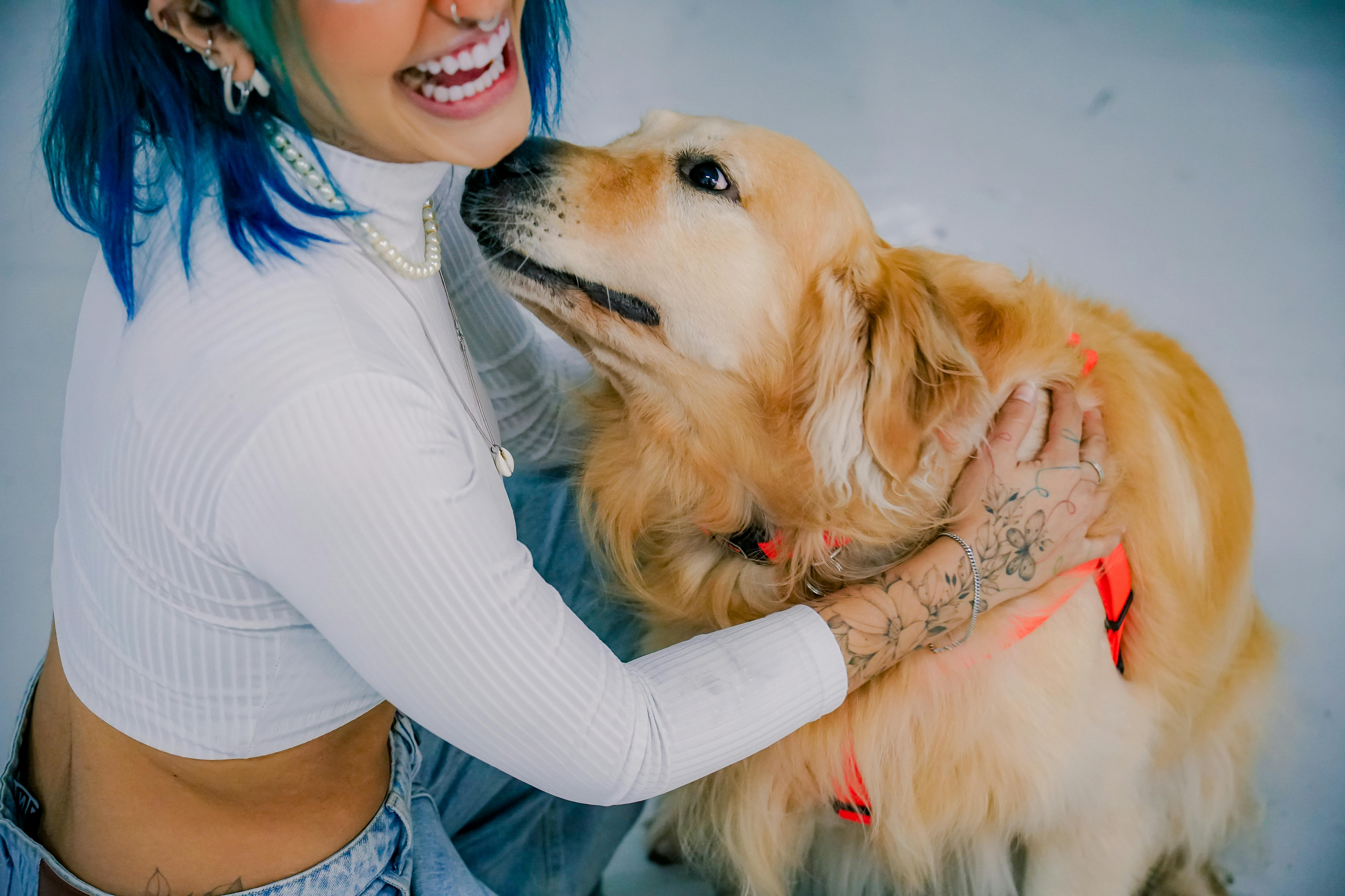 happy woman petting her golden retriever dog